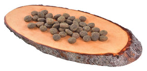 Croquettes naturelles Carnilove pour chien exposées sur un morceau de bois.