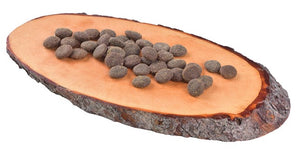 Croquettes naturelles Carnilove pour chien exposées sur un morceau de bois.